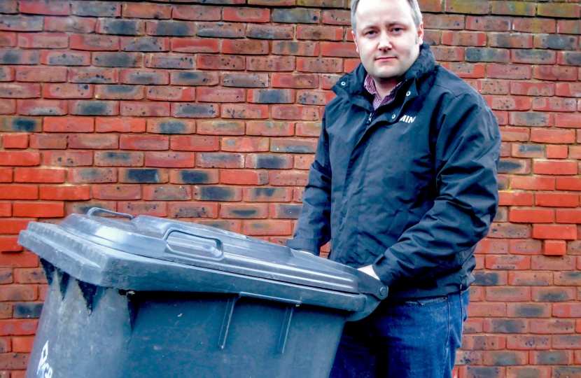 Darren Millar with a grey wheely bin