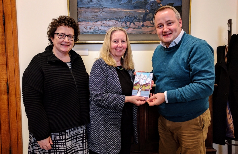 Ceredigion AM Elin Jones alongside Linda Tomos of the National Library of Wales receiving a copy of Elin's Air from Darren Millar AM. 