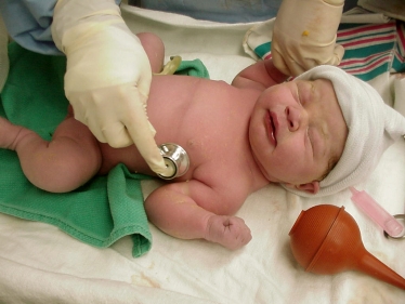Baby being seen by medical professionals in a hospital setting 